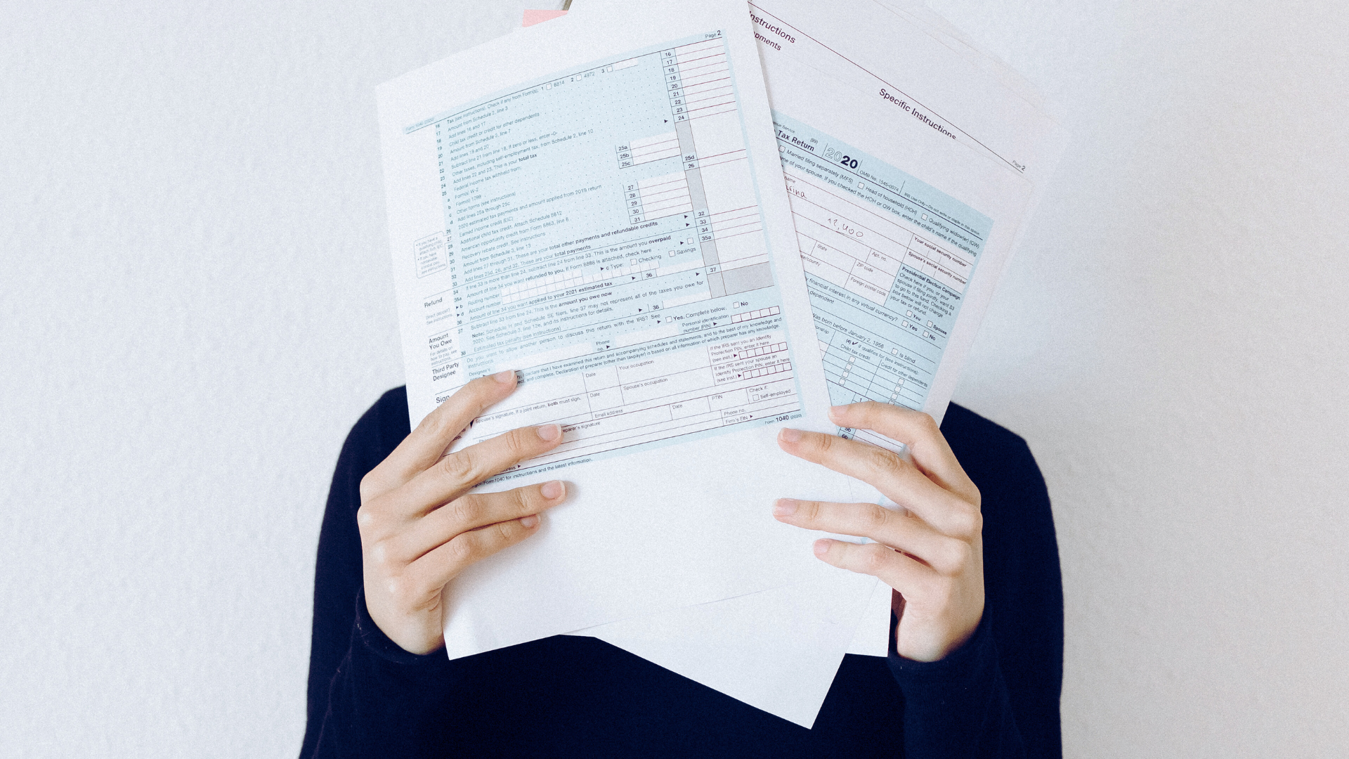 A woman covering her face with documents