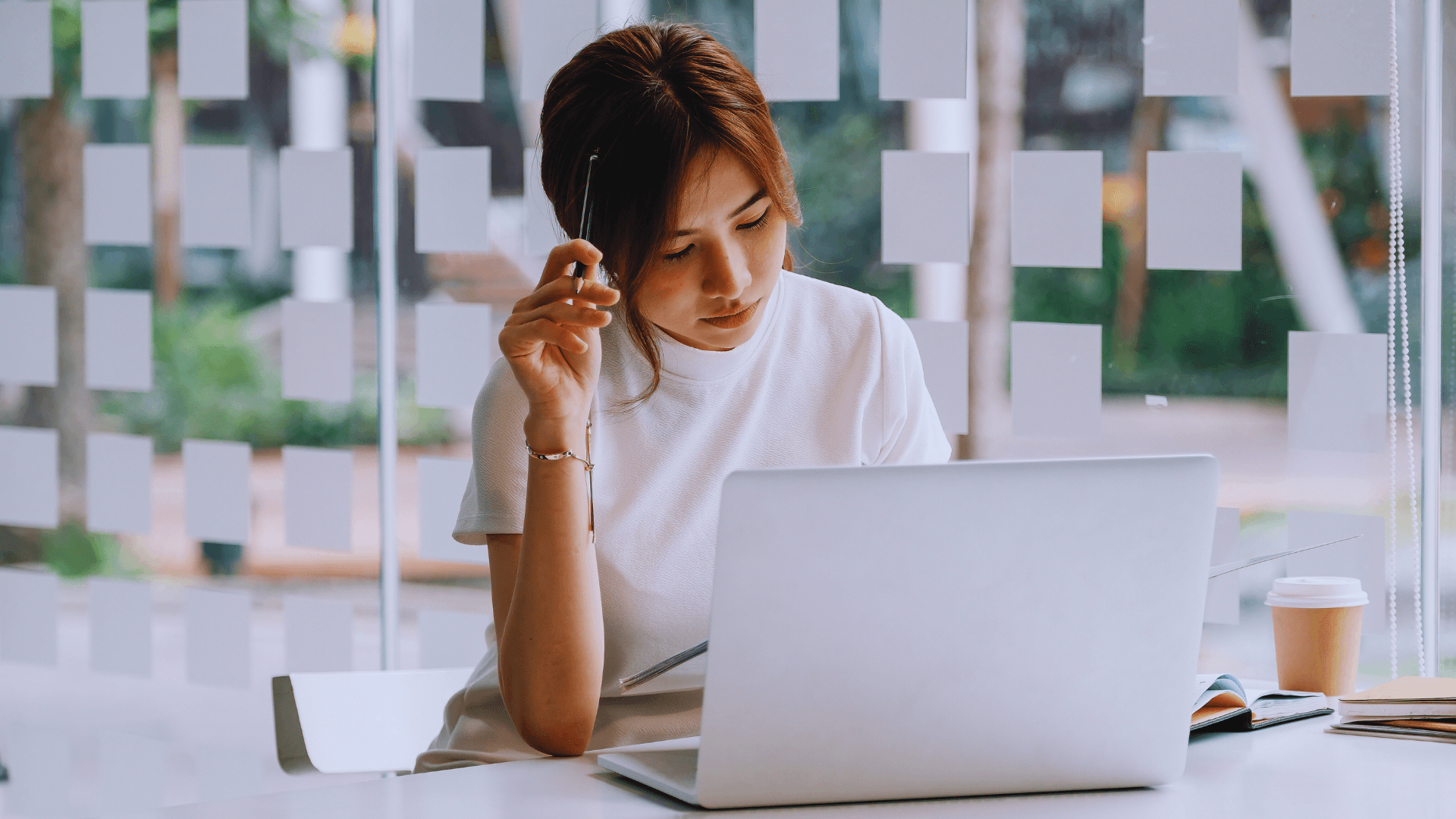 A woman thinking in front of her laptop