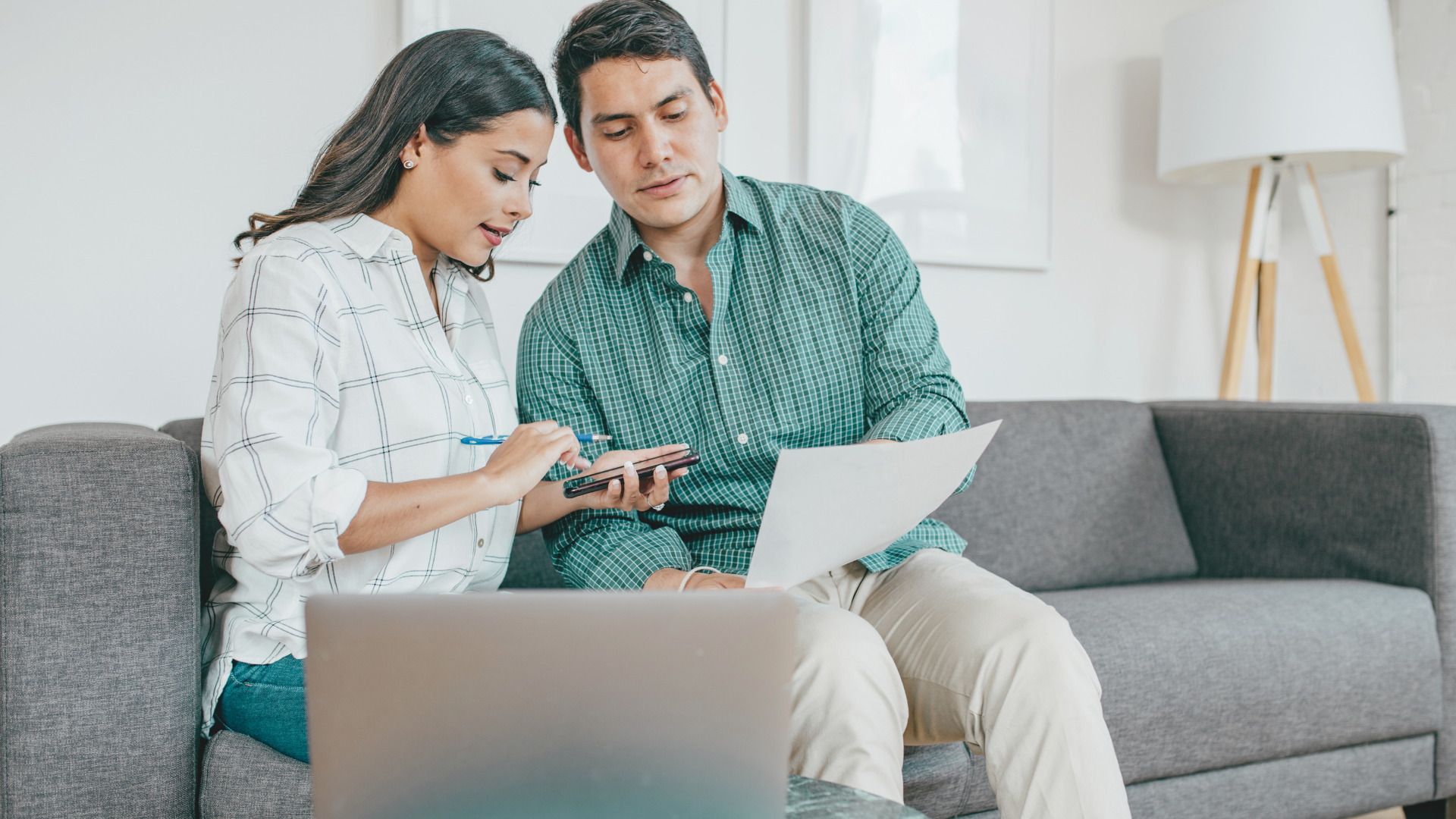 Married couple in a couch looking at a document