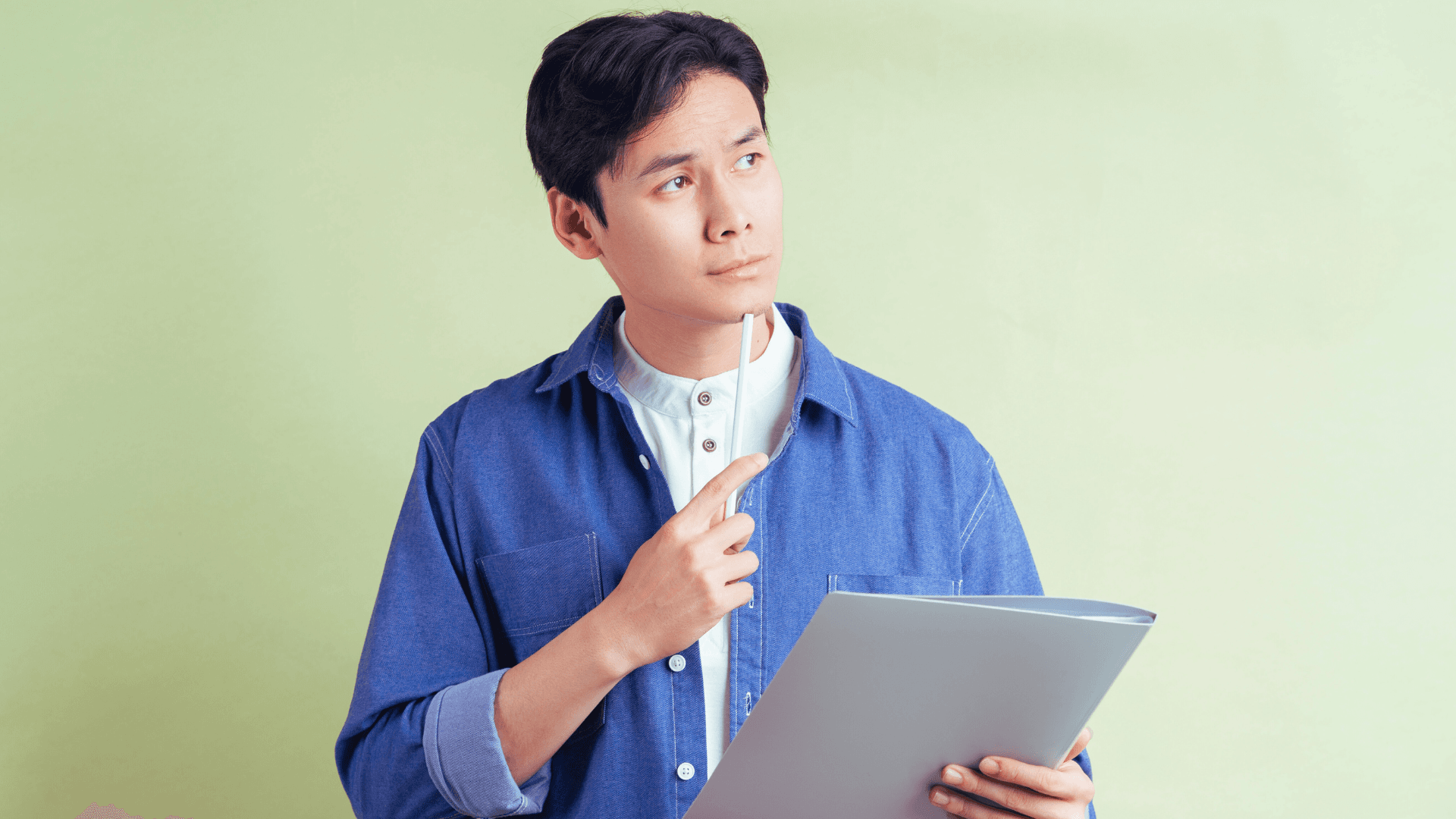 Teenager thinking while holding a pen